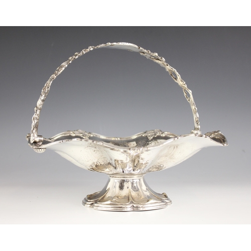 147 - A silver plated swing handled fruit bowl, the cast pierced floral handle above a conforming engraved... 