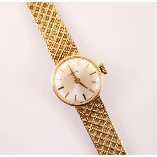 158 - A 9ct gold ladies Garrard wristwatch, the circular cream coloured dial with Arabic numeral and baton... 