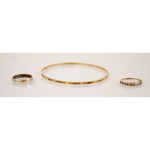 178 - A 9ct gold bangle, the bangle with a continuous cross decoration, marked for ‘JC London’ with a whit... 