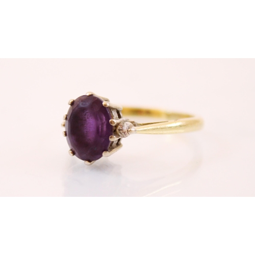 179 - An amethyst and diamond three stone ring, the central oval cut amethyst (estimated 2 carats) with tw... 