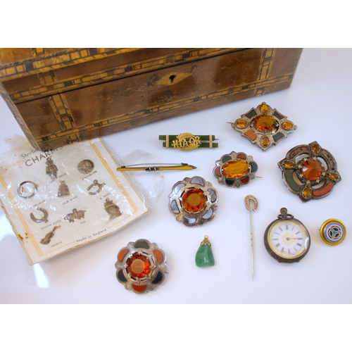 192 - A selection of costume jewellery, to include five silver coloured Scottish brooches, set with orange... 