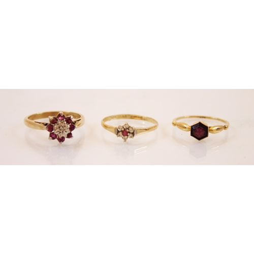 193 - A ruby and diamond 9ct gold cluster ring, the central raised illusion set diamond chip within a surr... 