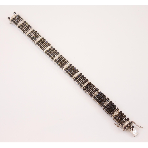 214 - A diamond and sapphire panel bracelet, designed as a continuation of four rows of round cut sapphire... 