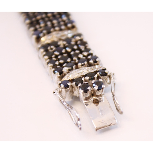 214 - A diamond and sapphire panel bracelet, designed as a continuation of four rows of round cut sapphire... 