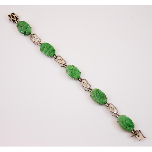 222 - A jade panel bracelet, the five carved jade panels modelled with floral decoration interspersed with... 