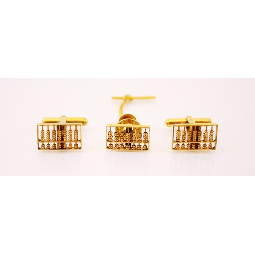 236 - A pair of gold coloured cufflinks, each designed as abacus, stamped 14k, with a similar stud with sa... 