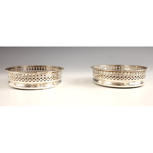 43 - A pair of silver plated bottle coasters, the rope twist rim above pierced and engraved decoration an... 