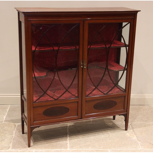 824 - An Edwardian mahogany display cabinet, the moulded cornice over a pair of astragal glazed doors, ope... 