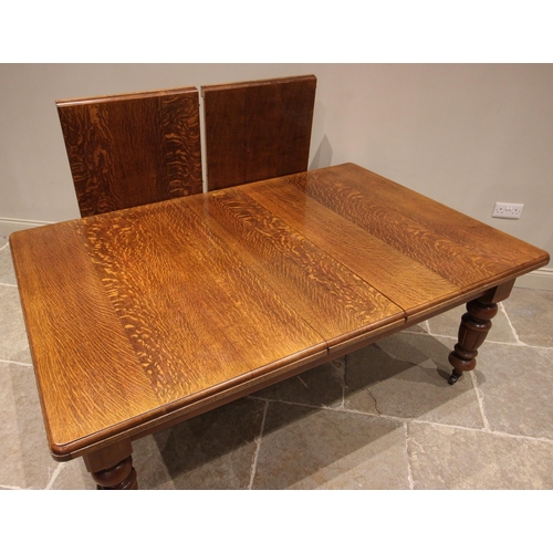 780 - A Victorian oak extending dining table, the rectangular moulded top upon fluted vase shaped legs cul... 