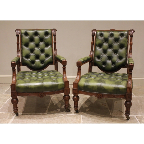 784 - A pair of Victorian oak and olive green leather library chairs, in the manner of Holland & Sons, the... 