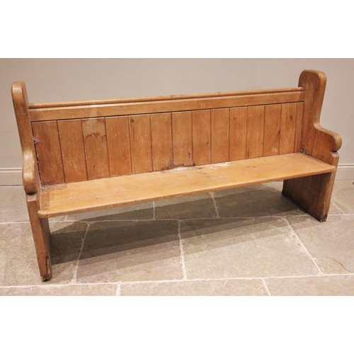 793 - A Victorian pine pew, the shaped end supports united by a board seat, panelled back and rear book sh... 