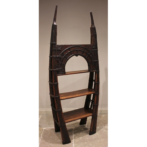 804 - An Indian hardwood reclaimed cart bookcase, of bowed form, the arched pediment over three open shelv... 