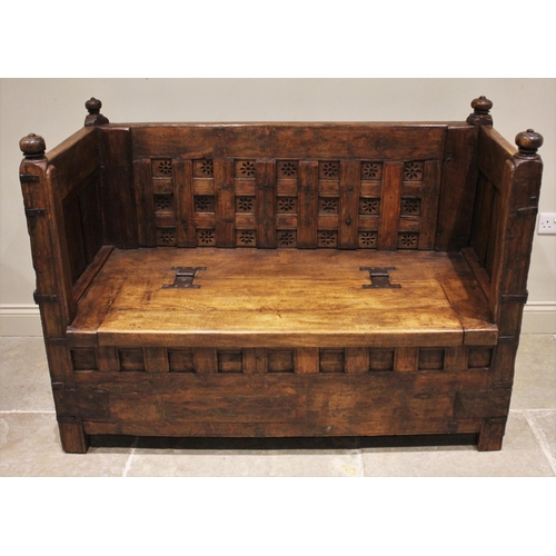 805 - An Indian hardwood box settle, 19th century and later, the panelled back board punctuated with pierc... 