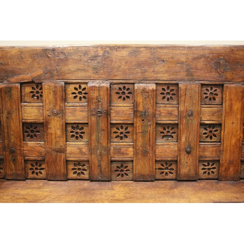 805 - An Indian hardwood box settle, 19th century and later, the panelled back board punctuated with pierc... 