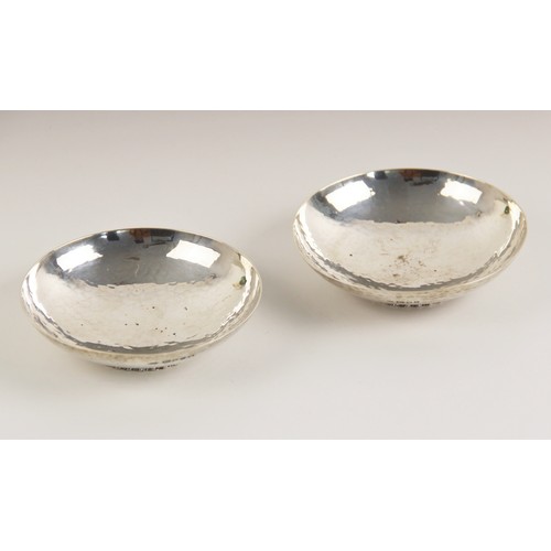 44 - A near pair of George V silver bonbon dishes, 'C.E' London 1932 and 1935, the circular planished bow... 