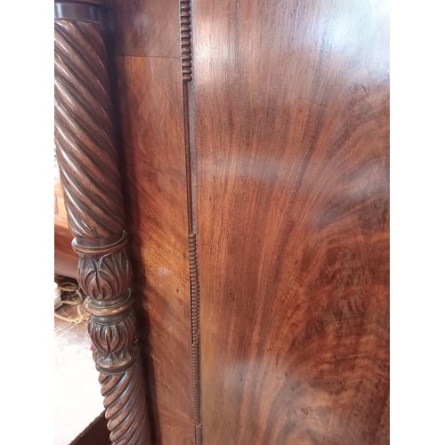 809 - A William IV mahogany linen press, the moulded cornice over an arched frieze extending to wrythen an... 