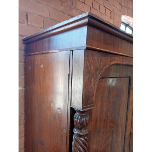 809 - A William IV mahogany linen press, the moulded cornice over an arched frieze extending to wrythen an... 