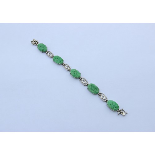 222 - A jade panel bracelet, the five carved jade panels modelled with floral decoration interspersed with... 