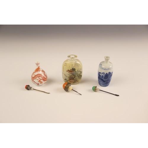 425 - Three Chinese snuff bottles and stoppers, comprising; a reverse painted rounded rectangular example,... 