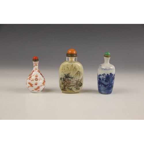 425 - Three Chinese snuff bottles and stoppers, comprising; a reverse painted rounded rectangular example,... 