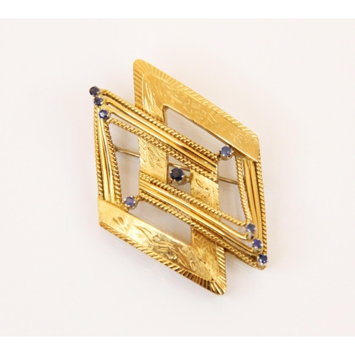 115 - A sapphire set yellow metal brooch, the brooch designed as two entwined yellow metal stylised diamon... 