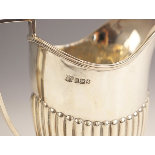 23 - An Edwardian silver milk jug, John Turton and Sons, Sheffield 1908, the grooved rim with conforming ... 