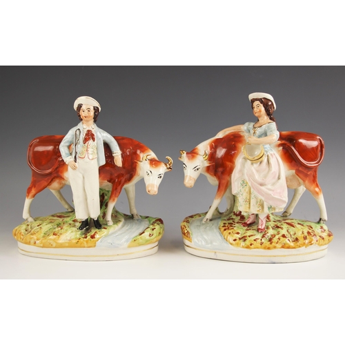 390 - A pair of Staffordshire figures, 19th century, one modelled as a farm boy with cow, 25.5 cm high, th... 