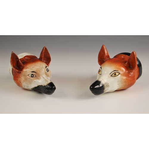 418 - A pair of Staffordshire stirrup cups, 19th century, each naturalistically modelled as a fox mask, on... 