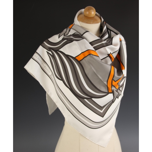 574 - An Hermes silk scarf, in the Quadridge II pattern designed by Pierre Peron, in grey and orange, with... 