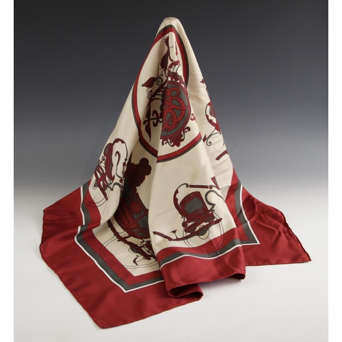 577 - An Hermes silk scarf, in the 'Ex Libris' pattern designed by Hugo Grygkar, in wine and grey, with ro... 