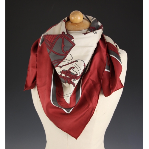 577 - An Hermes silk scarf, in the 'Ex Libris' pattern designed by Hugo Grygkar, in wine and grey, with ro... 