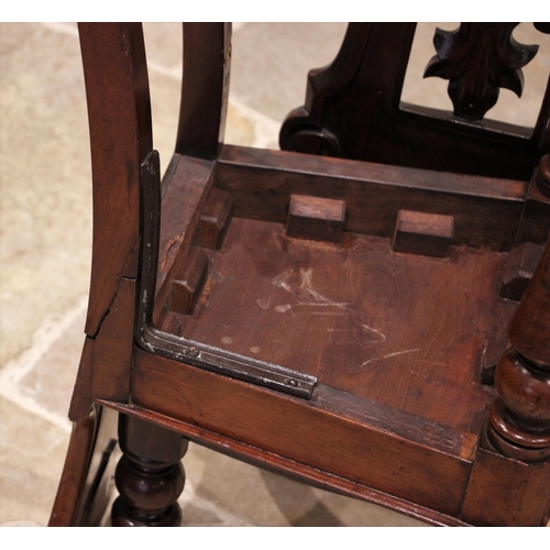 745 - A Victorian mahogany hall chair, the arched back centred with an openwork shield and foliate motif o... 