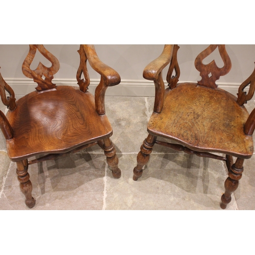 748 - A near pair of Victorian elm and beech smokers bow elbow chairs, each with a down swept arm rest and... 