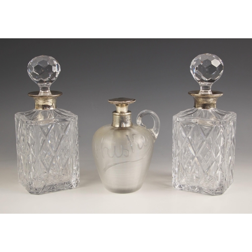8 - A pair of silver collared decanters, London 1979, the rectangular glass body with canted corners and... 