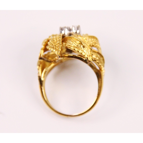 110 - A diamond yellow metal cocktail ring, the central three round cut diamonds in raised white metal set... 