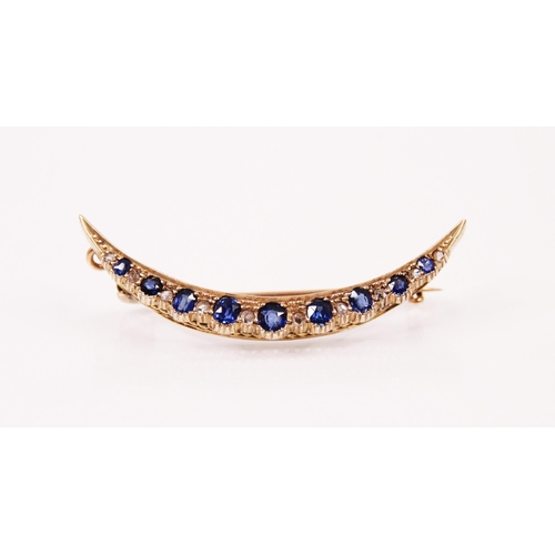 124 - A synthetic sapphire and diamond crescent brooch, the alternating oval cut synthetic sapphires inter... 