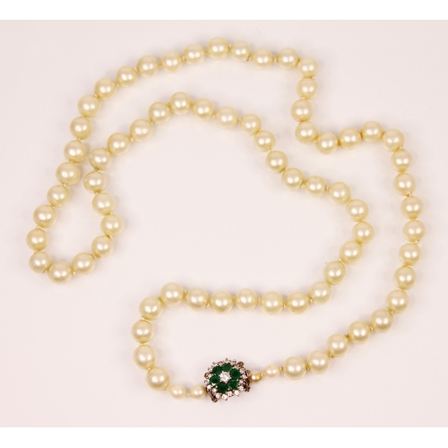 145 - A string of cultured pearls with emerald and diamond clasp, the cluster designed clasp with central ... 