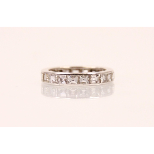 147 - A square cut diamond eternity ring, the twenty one square cut diamonds channel set within a white me... 