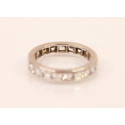 147 - A square cut diamond eternity ring, the twenty one square cut diamonds channel set within a white me... 