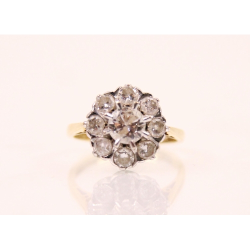 148 - A late 20th century diamond cluster ring, the central round cut diamond claw set within a surround o... 