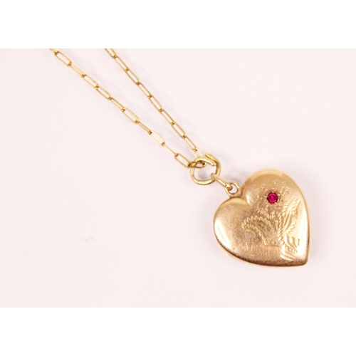 164 - A yellow metal heart shaped pendant, the pendant with untested ruby set to engraved flower, upon an ... 