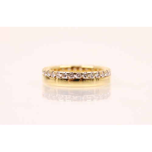 173 - A diamond and yellow metal eternity ring, the continuous round cut diamonds claw and channel set abo... 