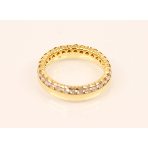 173 - A diamond and yellow metal eternity ring, the continuous round cut diamonds claw and channel set abo... 