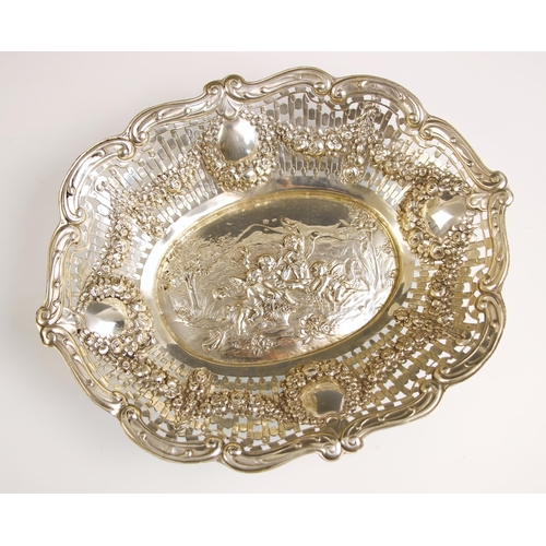 4 - A Continental silver coloured dish, the pierced foliate border with four floral embossed basket deco... 