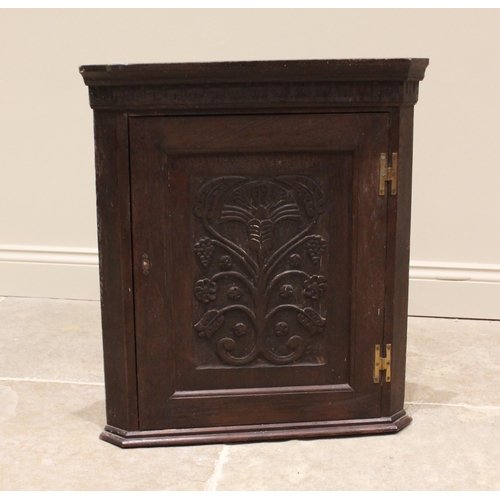 764 - A 17th century style oak wall hanging corner cupboard, late 19th century, the moulded cornice over a... 