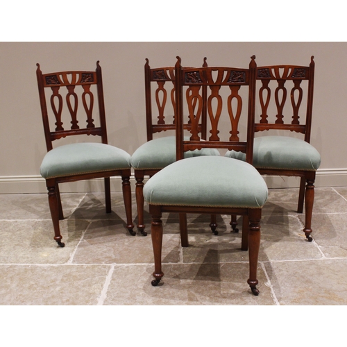 788 - A set of four Edwardian walnut and stained beech wood dining chairs, each with three pierced inverte... 