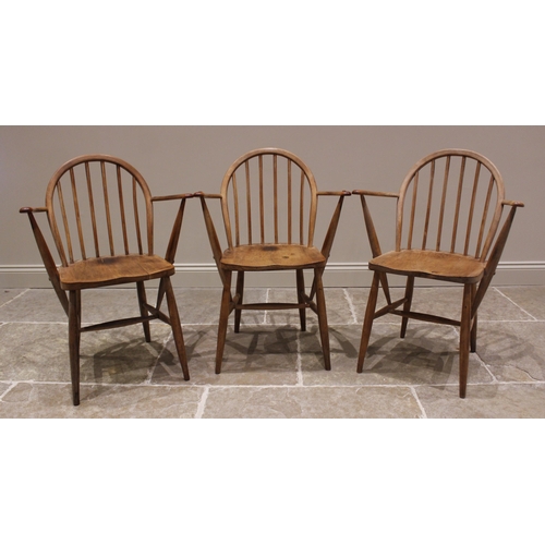 798 - A trio of elm and beech Ercol type elbow chairs, mid 20th century, each with a hoop back, out swept ... 