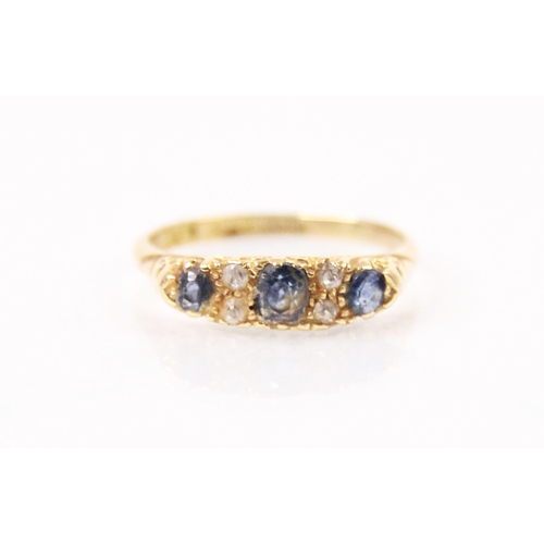 135 - An Edwardian sapphire and diamond ring, the central cushion cut sapphire with a further cushion cut ... 