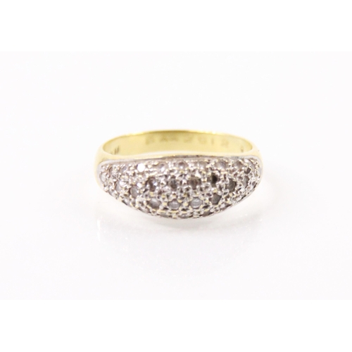 136 - A diamond and yellow metal bombe ring, the round cut diamonds set within a white metal mount, leadin... 