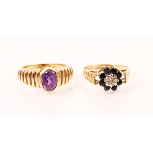 137 - An amethyst and yellow metal ring, the oval cut amethyst in a rubover setting, set within openwork s... 